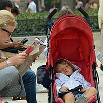 Kind schläft Mutter studiert Reiseführer