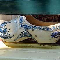 bemalter Holzschuh zwischen Fenster